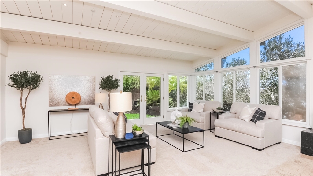 Bright living room with beamed ceilings opening to the garden